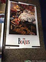 Poster with a room scene featuring a guitar and Beatles imagery, titled 'The Beatles'.