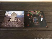 Both vinyl albums laid flat on a wooden surface, showing full album cover art for 'Who's Next' on the left and 'It's Hard' on the right.