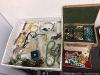 Wide top-down photo of the lot showing multiple jewelry pieces including watches, bracelets, necklaces, earrings, and rings inside grid pattern trays and jewelry boxes.