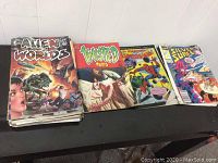 Stack of vintage comics showing Alien Worlds, Twisted Tales, Amazing Spider-Man, and Silent Surfer on top.