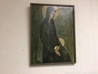 Full vintage framed print showing woman with halo, hanging on light-colored wall.