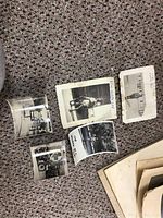 Five vintage black-and-white photos on textured carpet showing wear and curling edges.