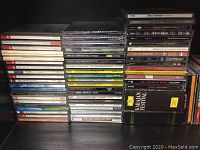 Stack of mixed CDs showing various classical symphony CDs and some pop and rock artists