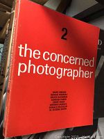 Front cover of 'The Concerned Photographer 2' photography book with red cover and white text.