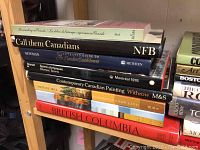 Stack of hardcover books about Canadian culture, history, and art including 'British Columbia', 'Contemporary Canadian Painting', 'Montreal 1976', 'Call Them Canadians'
