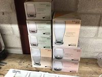 Boxed new Libbey branded cocktail, beer, and wine glasses stacked on a shelf.