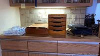 Photo of wooden office sorters, flatware storage containers, and Sony VHS DVD player on wooden countertop.