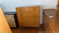 Front view of four‐drawer dresser with honey wood veneer and round knobs