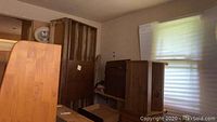 Photo showing side view of wooden dresser pieces assembled in room, highlighting wood grain and structure.