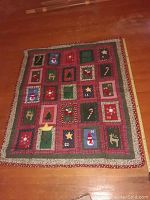 Photo of the handmade Christmas quilt displaying patchwork design with Christmas-themed squares and numbering