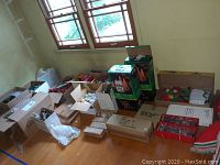 Wide shot of the lot showing many unopened boxes of Christmas decorations including lights, ornaments, and tree frames