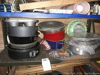 Shelved assortment of springform pans, tart pans, and cake molds stacked together