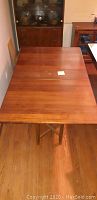 Top view of open table showing three-panel wooden surface with minor stain