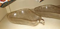 5 clear glass dishes shaped like pears with small handles, side view