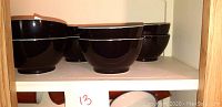 Top shelf showing 4 navy blue ceramic bowls with glossy finish.