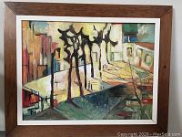 Full view of framed oil painting showing abstract urban landscape and teak frame