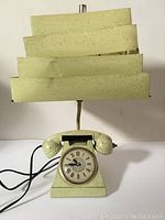 Front view of mid-century lamp with telephone style base showing clock dial and handset.