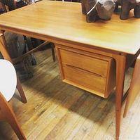 Angled front left view of desk highlighting top surface and drawer under the top