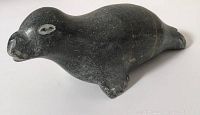 Full side view of the dark stone seal carving, showing shape and details.