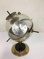Full view of globe weather station on brass pedestal