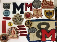 Top-down view of all fabric badges and pins arranged on a white background.