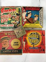 Five vintage film reels laid out showing colorful illustrated cardboard sleeves.