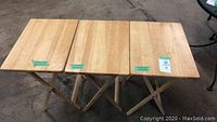 Front view of three wooden folding tables showing rectangular tops in light natural wood finish.