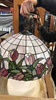 Front view of Tiffany style stained glass dome light fixture showing floral tulip pattern and brass hardware.