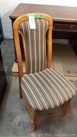 Full view of one dining chair showing maple wood frame and upholstered seat and back with striped fabric pattern.