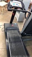 Photo of the treadmill showing the full length and running belt surface, including the safety key area.