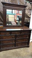 Front angled view of the dresser with the mirror placed on top showing wood grain finish and drawer details.
