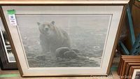 Full view of the framed print showing a large grizzly bear in a rocky landscape under a stormy sky, measuring approximately 41.5 by 35 inches.