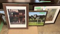 Framed art prints including one large Frank Panabaker limited edition print and two horse art prints with green tape on frame corners.