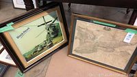 Two framed artworks side by side: Black Hawk helicopter photo and Ontario vintage map