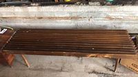 Full top view of the mid-century wooden slatted bench showing surface wear and scratches