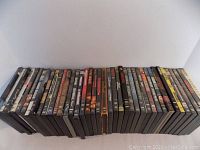 Photo showing the full collection of 40 DVD cases stacked horizontally, visibly worn cases in places