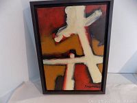 Frontal view of the painting showing abstract artwork in bold colors in brown frame.