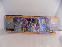 Full view of the sealed Star Wars panorama puzzle set with all three puzzles side by side inside shrink wrap, showing artwork of Star Wars characters.