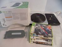 Xbox 360 original box, DJ Hero turntable controller, detachable hard drive, and five Xbox 360 game cases stacked.