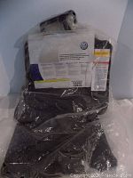 Set of 4 black rubber floor mats in original sealed plastic packaging with Volkswagen label.