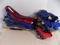Stacked kids pants and overalls in denim, red, blue and burgundy colors