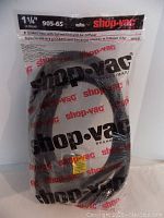 Photo of the intact original packaging showing the Shop Vac hose coiled inside. Brand and product details visible on the packaging.