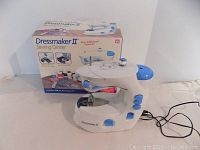 Full view of Dressmaker II sewing machine with original box in background.