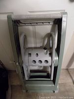 Top angle view of the plastic garden hose reel showing the winding drum with holes and handle.