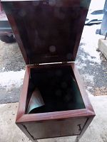 View of cabinet with lid open showing dark interior and peeling green lining