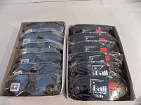 Top-down image of two boxes each containing 12 pairs of individually packaged sunglasses; one box showing sunglasses with clear lens labeling; the other box showing soft cases with brand name Bali Eyewear