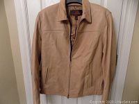Front view of the men's tan Danier leather jacket showing zipper and pocket details.