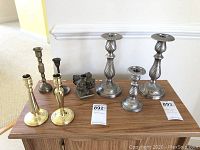 Full view of all candle holders on wooden surface showing arrangement and material variety