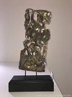 Front view of carved wooden artwork sculpture showing detailed figures and wear.