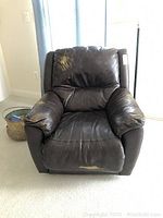 Front view of brown Lane recliner showing color fading and damage on back upper part, arms, and front lower edge.